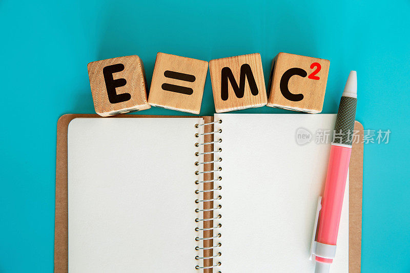 字母块- E=MC2在木块和空白螺旋笔记本